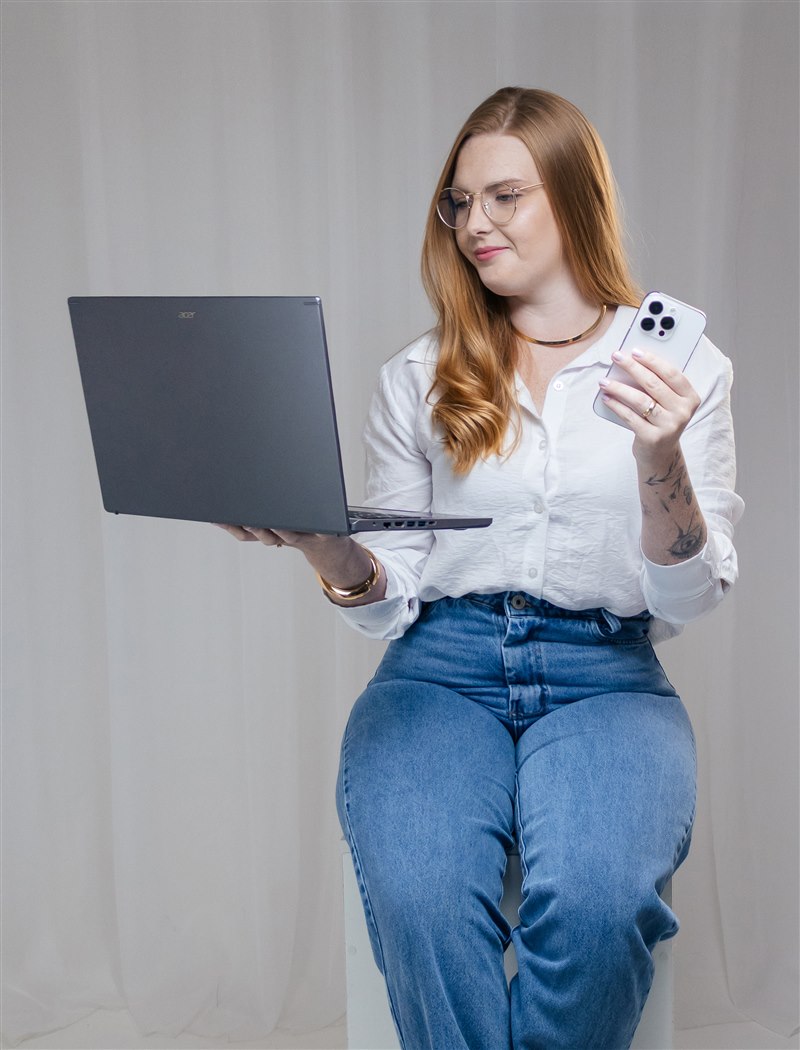 Amanda, fundadora da Domma, com um notebook e um celular